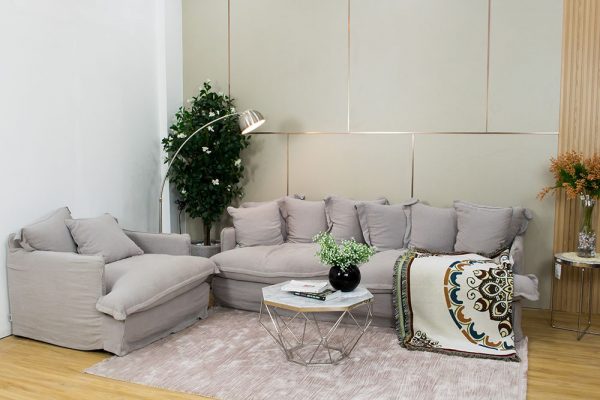 Bộ sofa vải màu xám nhạt, bàn trà mặt đá cẩm thạch, thảm lông màu hồng nhạt và tường trang trí hiện đại.
