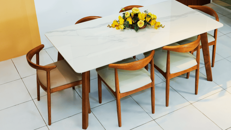 Bàn ăn mặt đá Hilton màu trắng vân mây, chân gỗ tự nhiên chắc chắn, kết hợp ghế ăn gỗ bo cong bọc nệm sáng màu, bố trí gọn gàng cho phòng ăn hiện đại.